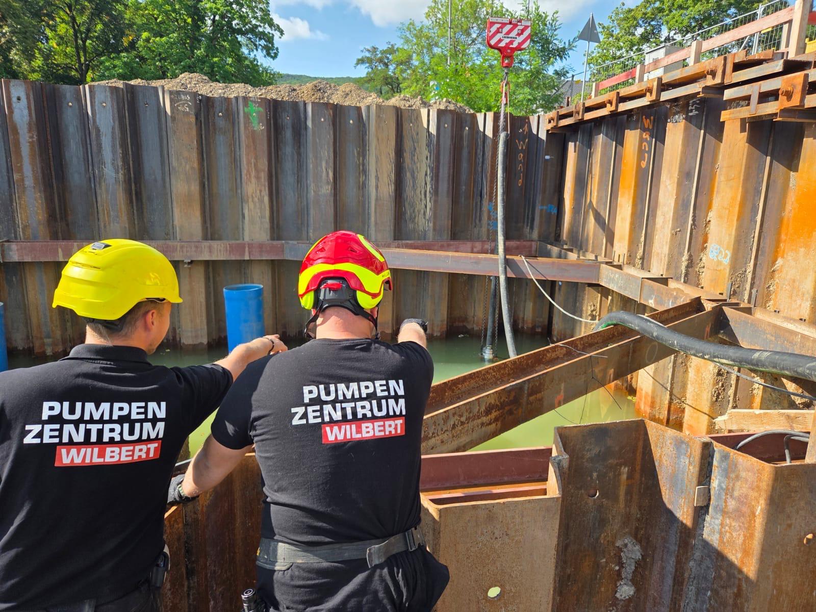 Zwei Monteure vom Pumpenzentrum Wilbert an einer Baugrube bei der Hebung einer Baupumpe