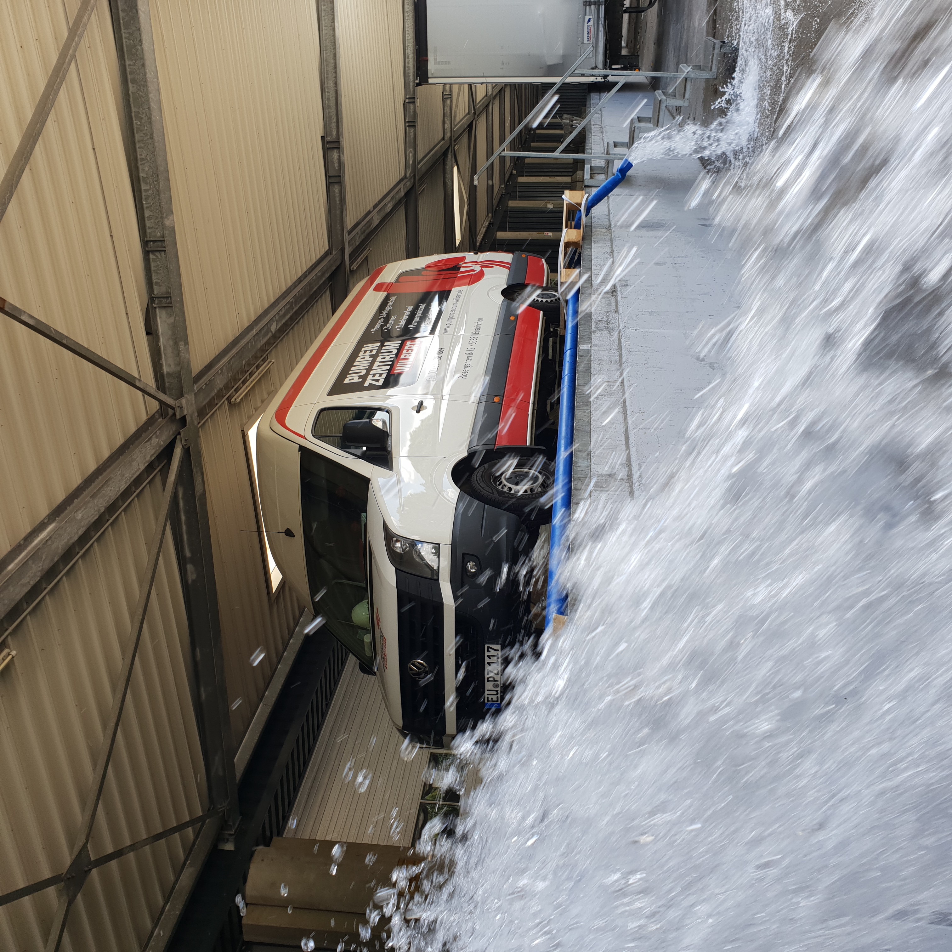 Montagefahrzeug vor einer Fabrikhalle bei der Abpumpung von großen Mengen Wasser